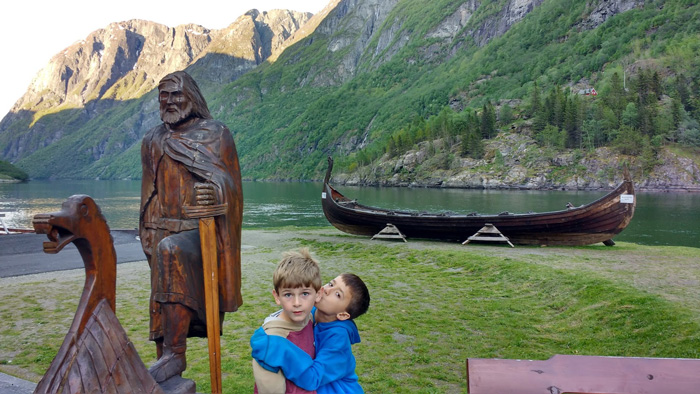 Luke kisses Matt in Norway surrounded by wood carvings - DJ Peace Pic